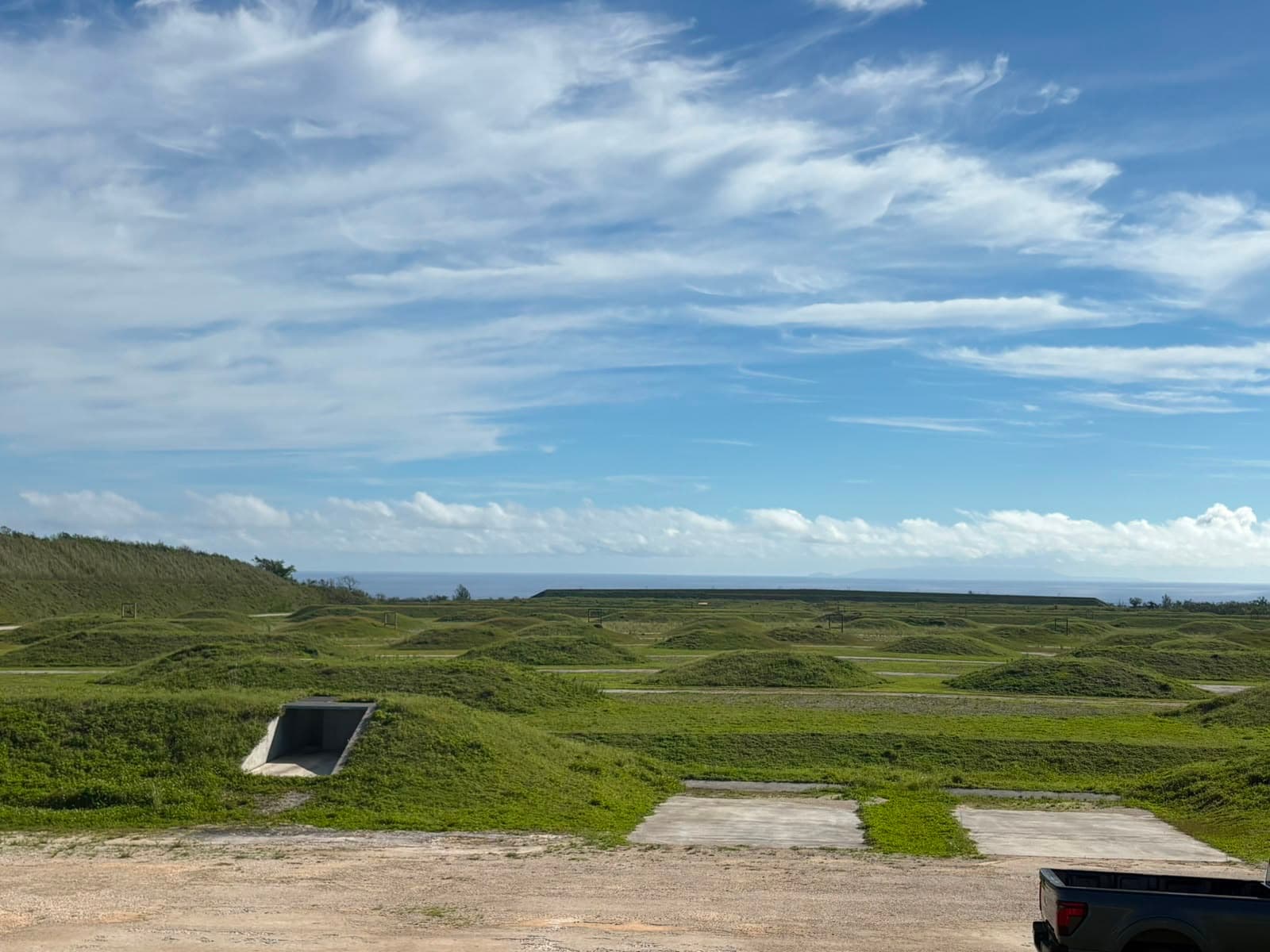 Live-fire range complex at Marine Corps Base Camp Blaz, Guam, with earthen berms and target frames overlooking the Pacific