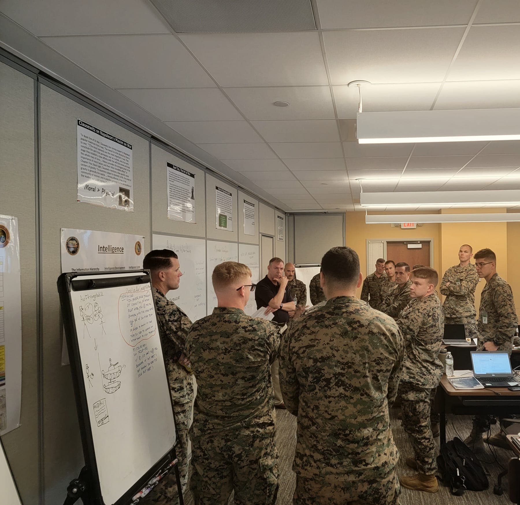 Marines gathered around whiteboards during a command and control training session