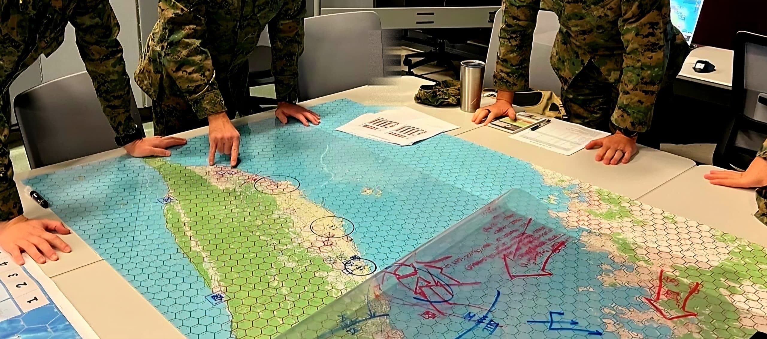 Marines working through a hex-map wargame during a Marine Corps University event